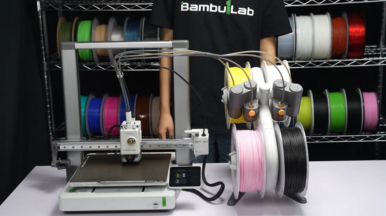 Bambu Lab A1 Combo completa: a impressora com o AMS Lite e 4 rolos de filamento ao lado